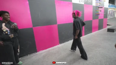 Two people near a black and pink checkered wall.