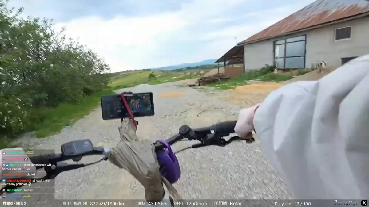 POV cycling on gravel road near rural building