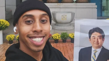 Johnny Somali posing in front of a statue