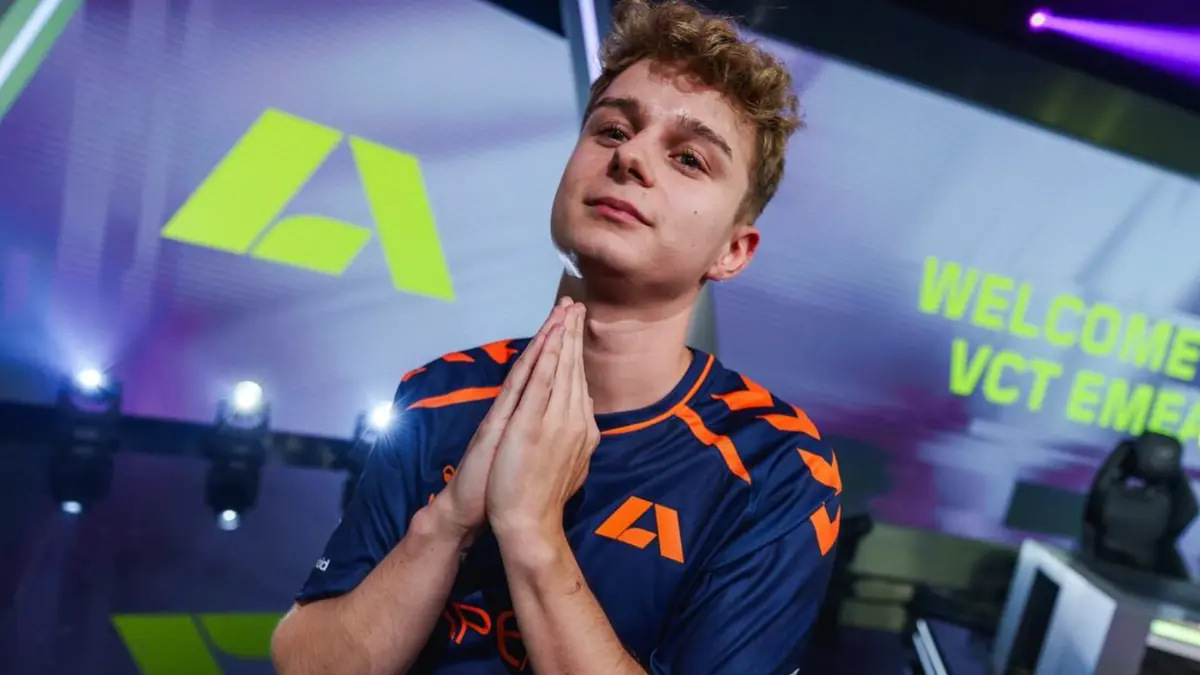 Esports player posing on stage in team jersey