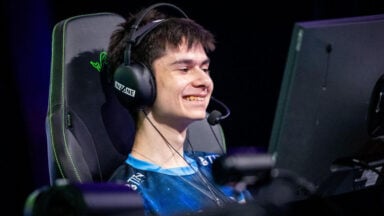 Smiling esports player wearing headset at computer
