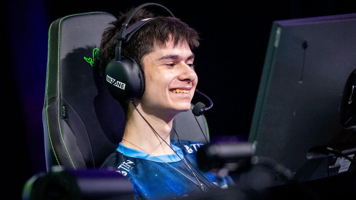 Smiling esports player wearing headset at computer