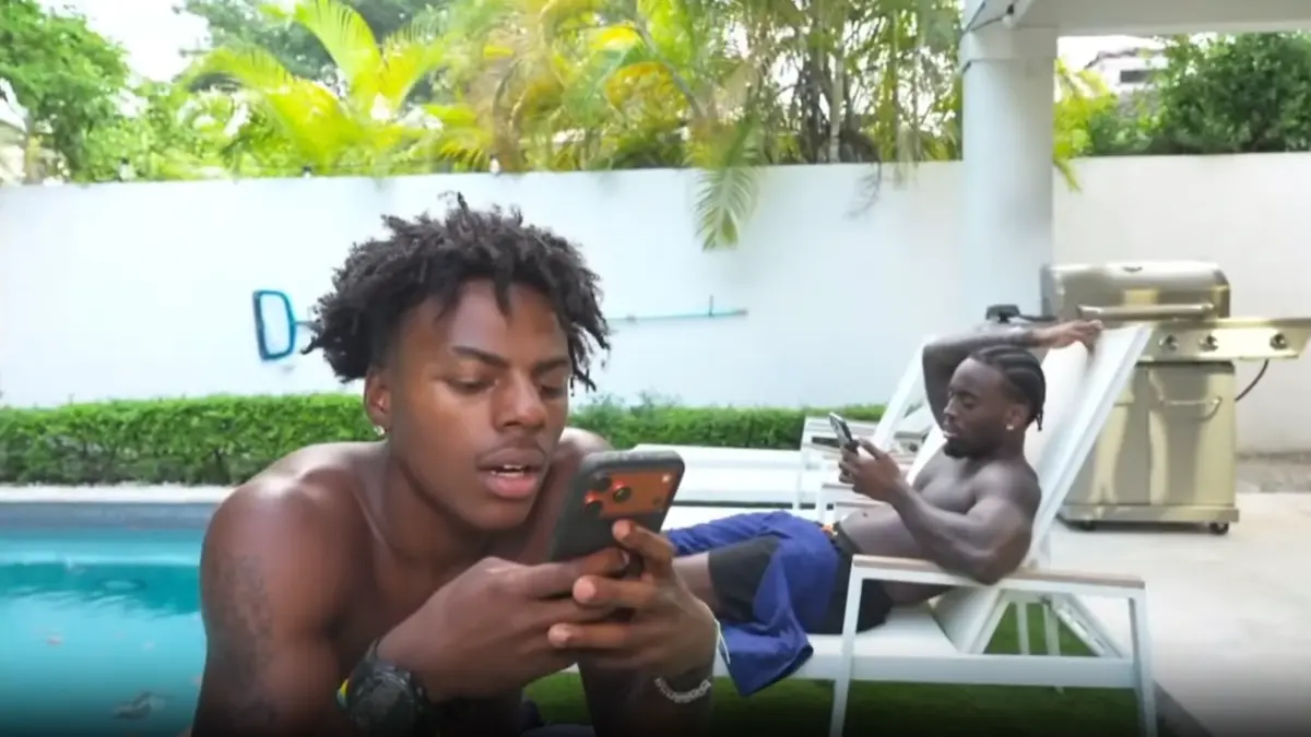 Two men using phones beside a tropical backyard pool