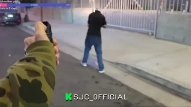 Person pointing gun at man on street