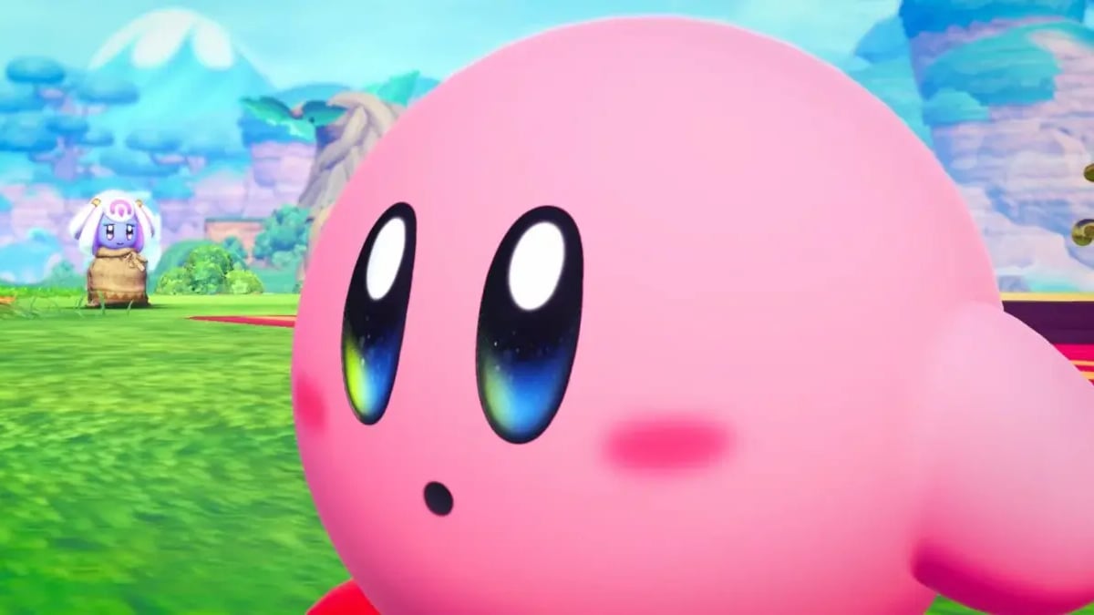 Close-up of Kirby in a colorful grassy game landscape