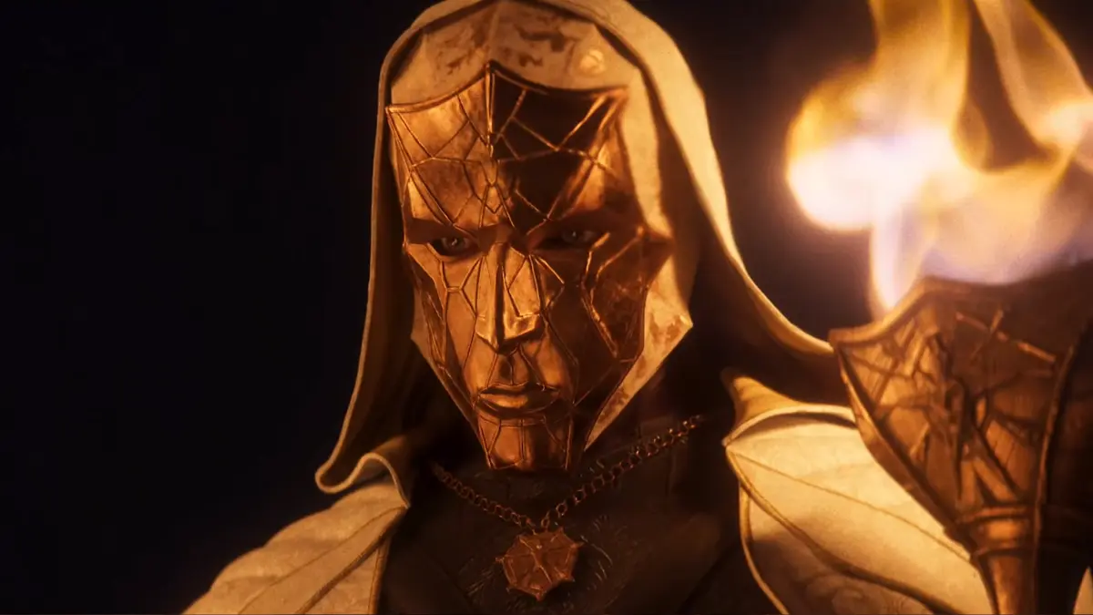 Hooded figure with golden mask holding torch