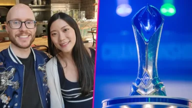 Smiling couple beside esports championship trophy