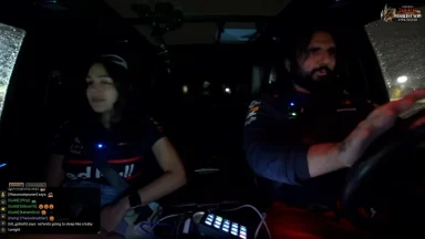Two people driving at night in a car