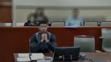 Man seated at courtroom desk with computer monitor