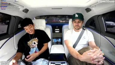Two men sitting in luxury car with small dog
