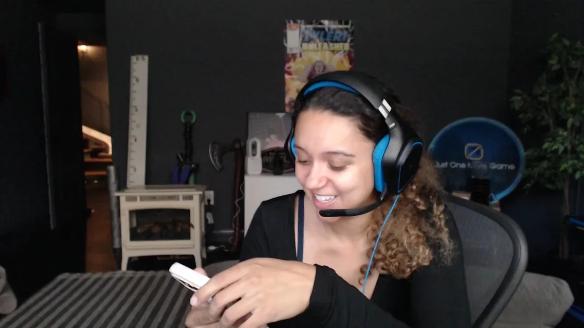 Person smiling while using smartphone and wearing headset