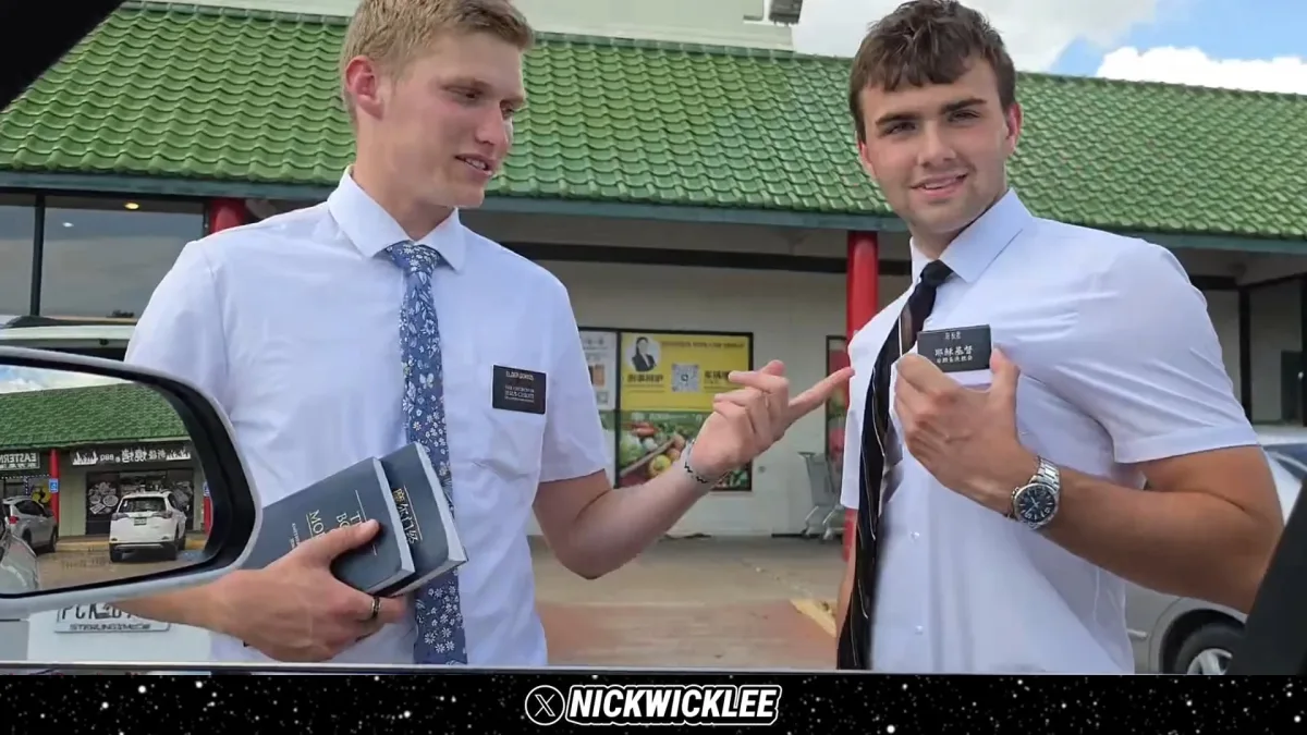 Two missionaries holding books outside storefront