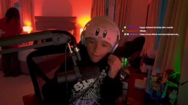 Person streaming with microphone and gaming headset.
