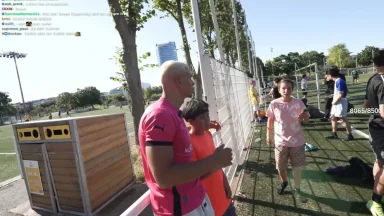 People chatting beside a soccer field.
