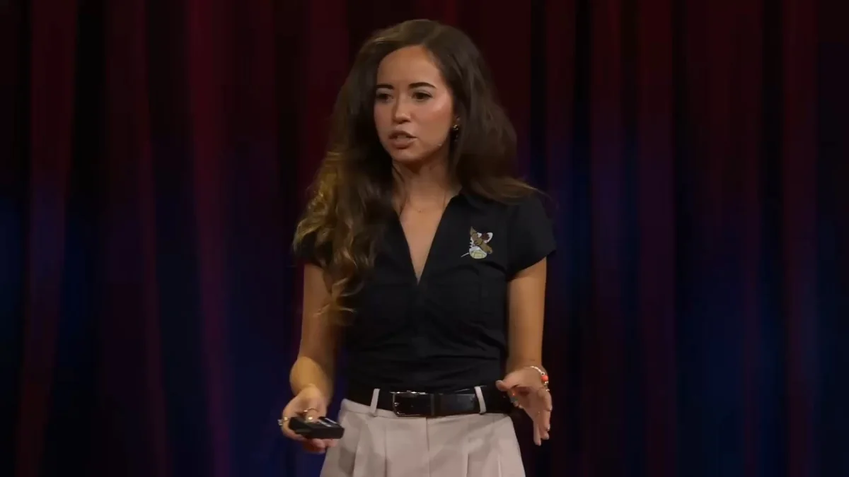 Woman giving presentation on stage with red curtains