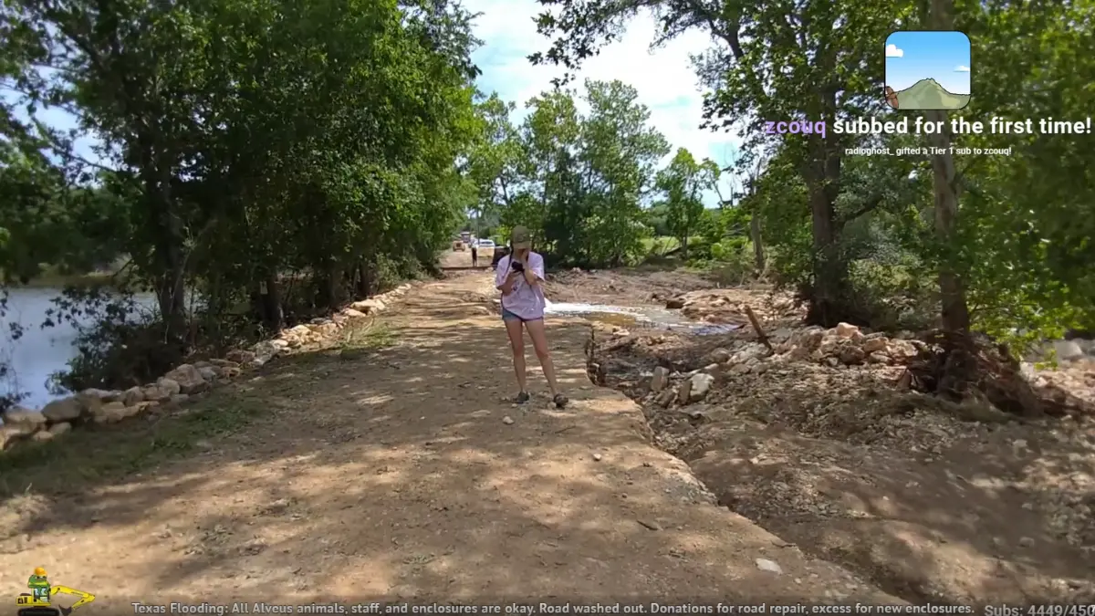 Person walking on washed-out dirt path after flood.
