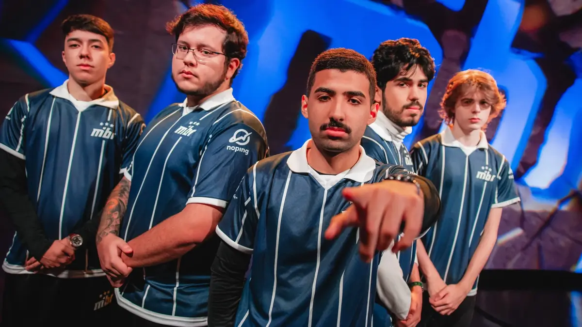 Five esports players in matching blue jerseys pose together