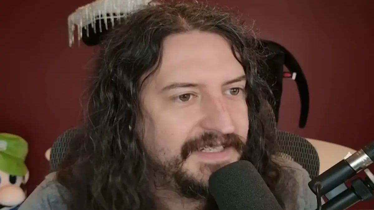 Long-haired man speaking into microphone during livestream