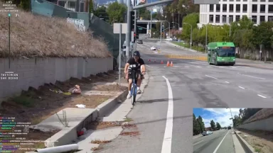 Cyclist riding on roadside near green city bus.