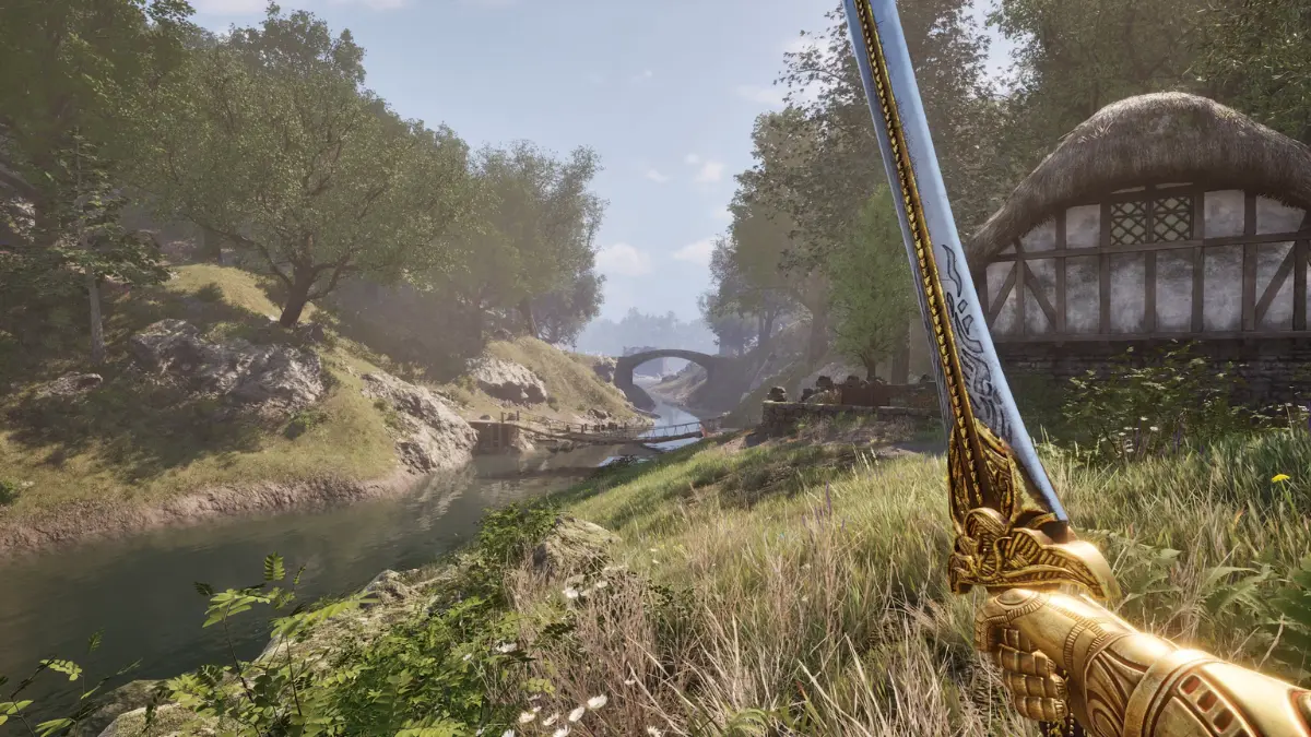 Person holds ornate sword in scenic countryside setting.