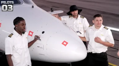 Three pilots standing beside small aircraft nose