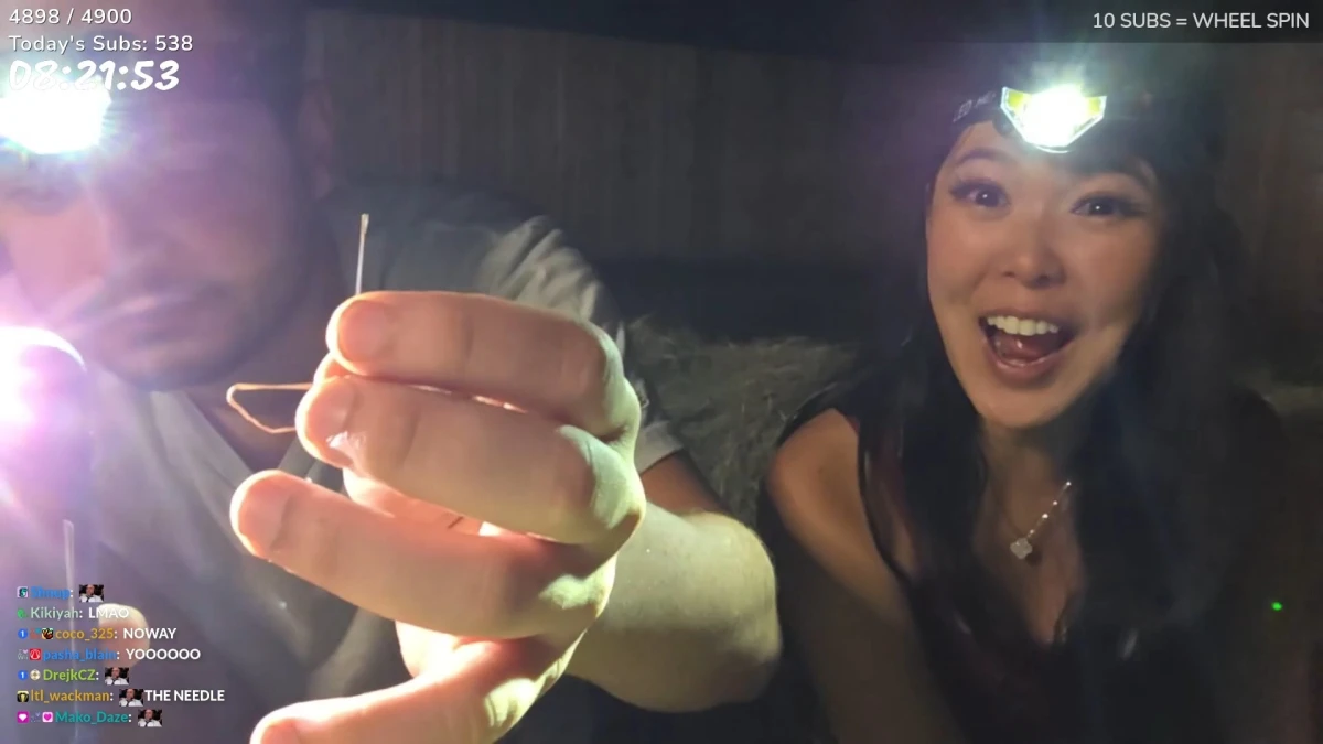 Two people with headlamps holding a needle
