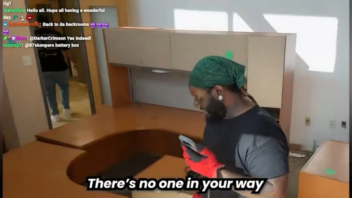 Man wearing gloves checks phone in empty office