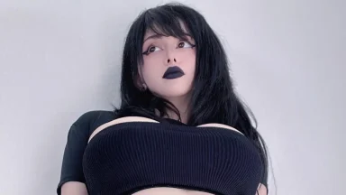 Person with dark hair and makeup, looking upwards.