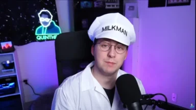 Man dressed as milkman speaking into microphone