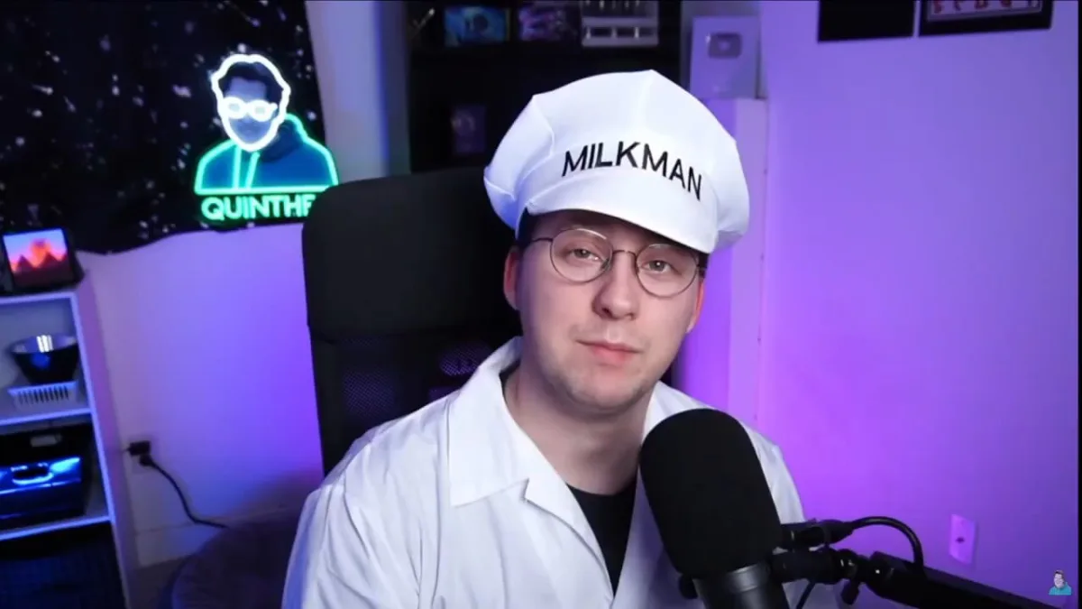 Man dressed as milkman speaking into microphone