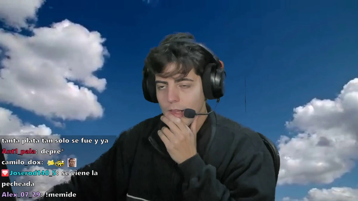Streamer wearing headset against cloudy blue sky background