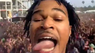 Man taking selfie before massive outdoor crowd