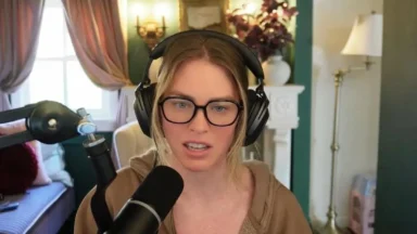 Woman wearing headphones speaks into microphone in home studio