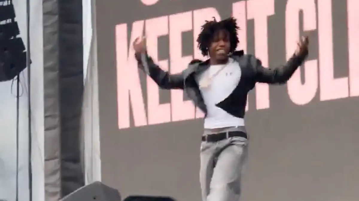 Performer dancing energetically on outdoor concert stage