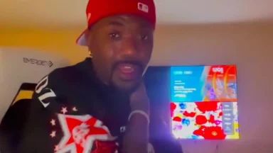 Person wearing red cap posing near colorful screen