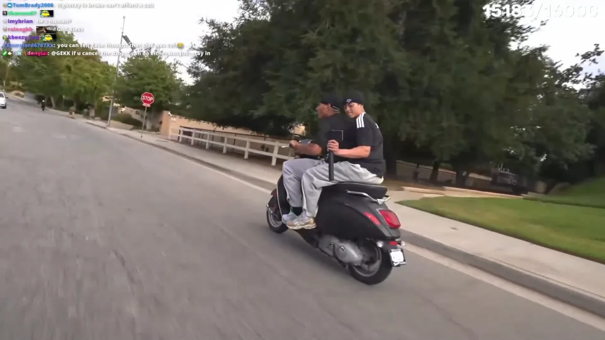 Two men riding scooter on suburban street