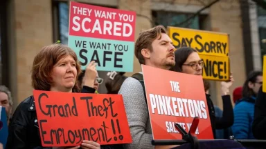 Protesters holding colorful signs at a demonstration