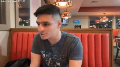 Man sitting in red booth at pizza restaurant
