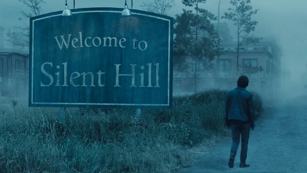 Person walking past Welcome to Silent Hill sign in fog