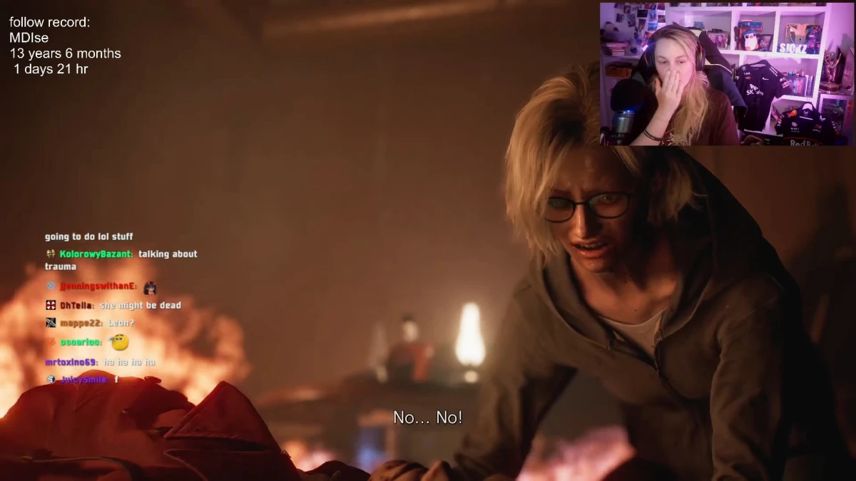 Streamed game scene with distressed character beside fire