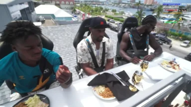 Three men dining on rooftop overlooking waterfront