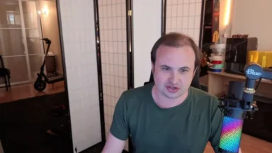 Man speaking into colorful microphone in home office