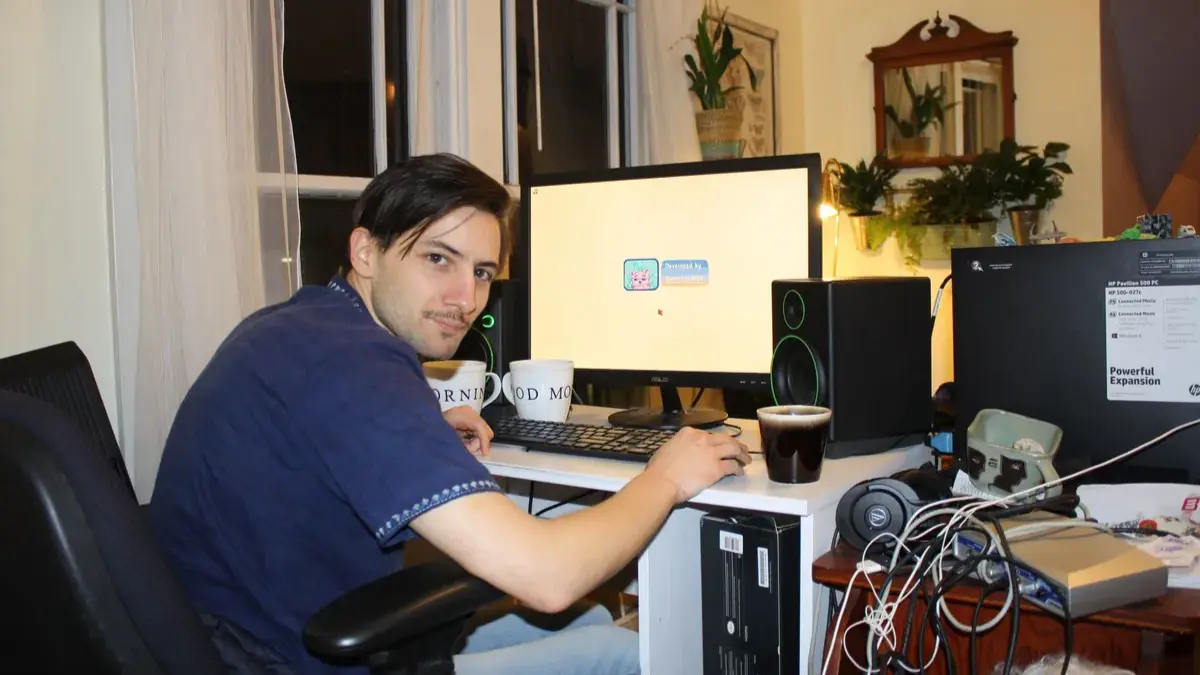 Person using desktop computer at home office.
