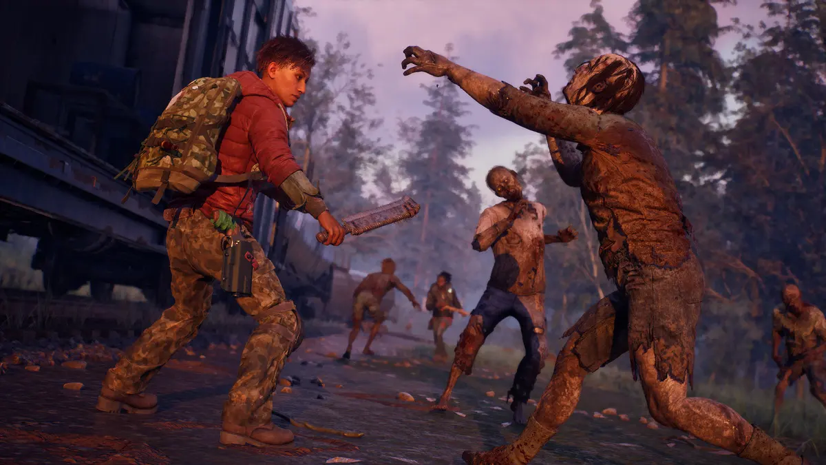 Survivor fights zombies near train at dusk