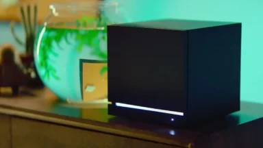 Modern black device beside illuminated aquarium tank