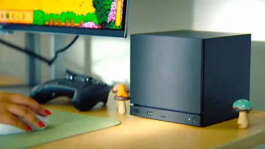 Compact gaming PC beside monitor and controller