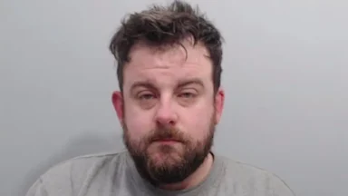 Bearded man in mugshot against plain background