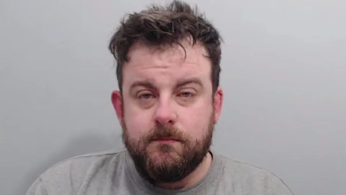 Bearded man in mugshot against plain background