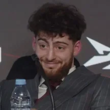Man in suit smiling during a press conference