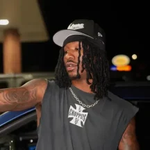 Man wearing black cap and sleeveless shirt at night